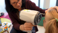 Orthoptistin scannt die Augen bei einem Kind