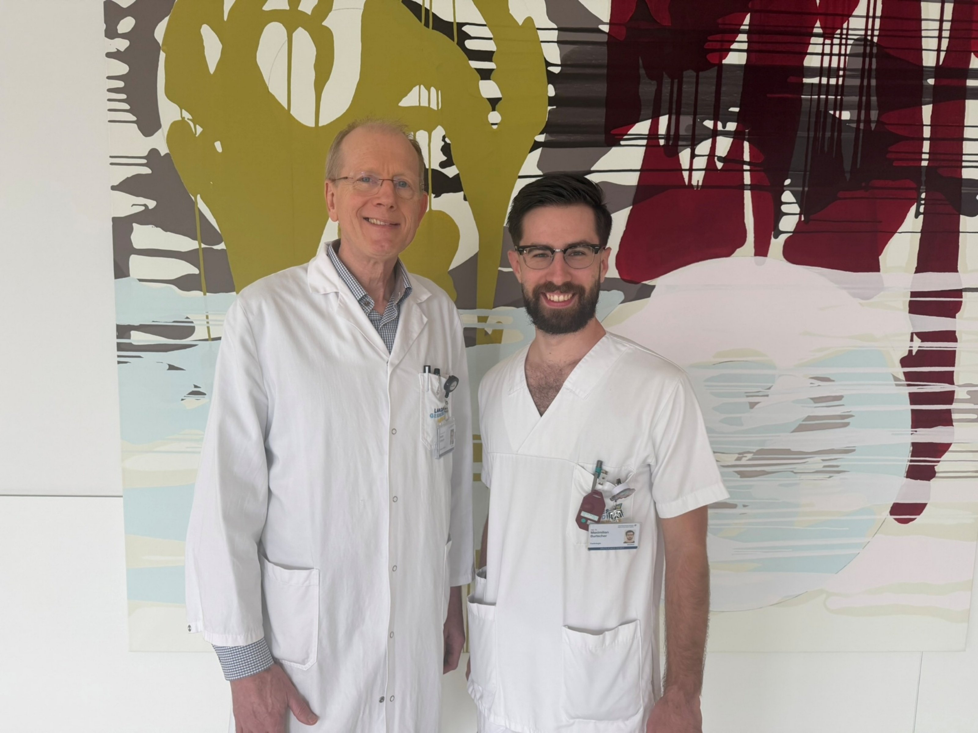 Prof. Dr. Gerhard Steinlechner und Maximilian Burtscher vor einem abstrakten Gemälde
